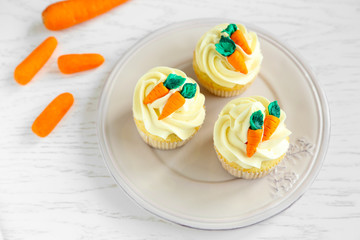 Plate with Easter cupcakes on wooden table