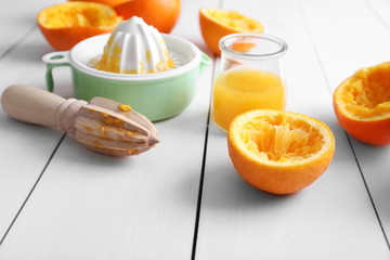 Juicing delicious oranges on white wooden table