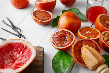 Juicing Sicilian oranges on white wooden table