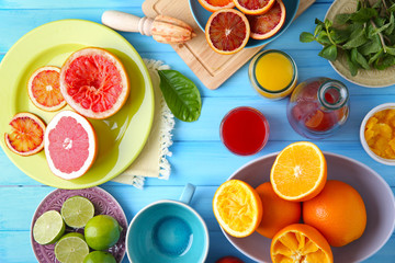 Juicing delicious citruses on blue wooden table