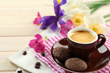 Obraz na płótnie Canvas Cup of coffee with cookies and flowers on wooden table