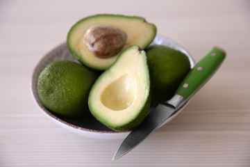 Fresh sliced avocado with knife on plate