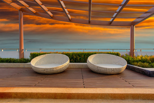 Relax Corner On Condominium Rooftop Garden With Chairs On Red Sky Sunset Background