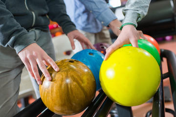 Closeup of men choosing their bowling ball