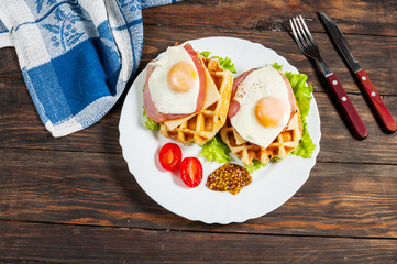 Belgian waffle with egg and salmon on wood table