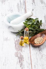Bottle with herbs on wooden background. Mint, thyme, balm and other medicinal herbs