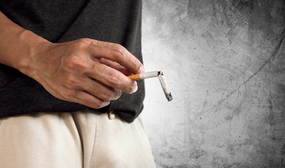 Hand holding burning break cigarette. concept of break quitting cigarette and cigarette's disease...