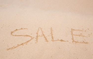 sale handwritten in sand on a beach