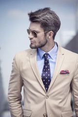 Handsome man in bright suit against the city