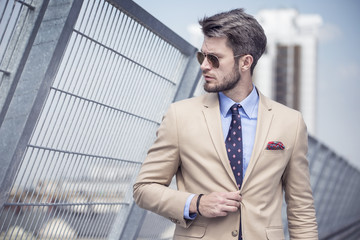 Handsome man in bright suit against the city