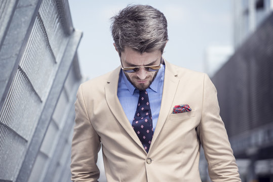 Handsome man in bright suit against the city