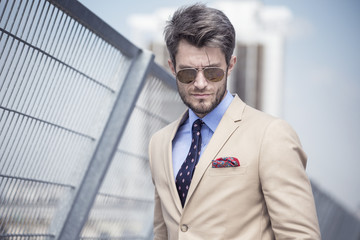 Handsome man in bright suit against the city