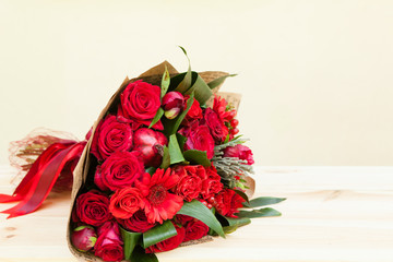 Red bouquet of roses, gerberas, peonies, pomegranates with copyspace. Love and passion symbol. Anniversary gift. Birthday gift for girl.