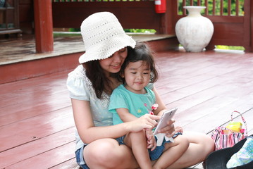 Mother and kid are playing mobile together