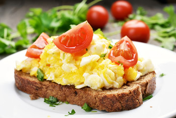 Scrambled eggs and tomato slices on bread