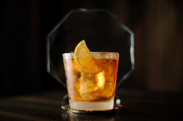 old fashioned cocktail with lemon on table 