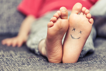 Kids feet with smiley faces drawings