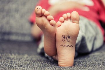 Kids feet with smiley faces drawings