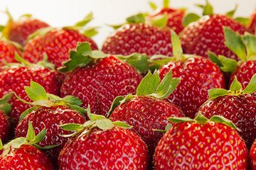 Strawberry background of whole strawberries in sunlight.  Colorful ripe berries  strawberries. Fruit background. Strawberry pattern. Spring background. Summer background. Top view. Macro. Texture.