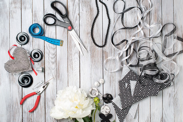 Scissors, buttons, accessories on white wooden background. Handmade workplace. Top view.