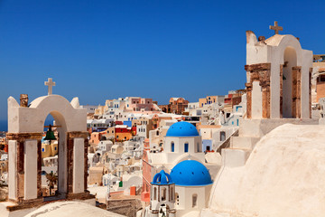 Landscape of Oia town, Santorini. Three blue domed churches and two bell towers on foreground