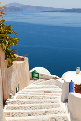 Street view in Oia, Santorini. The sea and volcano on background