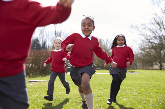 Elementary School Pupils Running In Playground At Breaktime