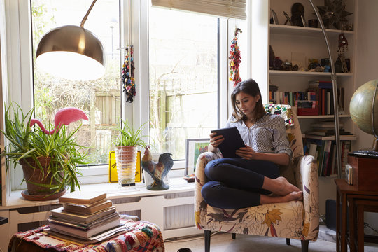 Woman Relaxing With Digital Tablet In Stylish Apartment