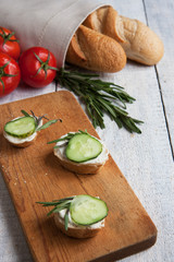 Canapes with cucumber for breakfast white wooden background