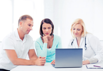 doctor with patients looking at laptop