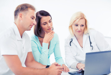 doctor with patients looking at laptop