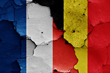 flags of France and Belgium painted on cracked wall