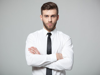 Studio shot of young handsome businessman on gray background.