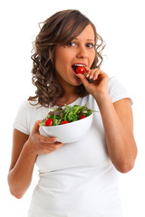 Young woman eating healthy salad with cheery tomatoes isolated on white background