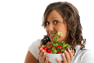 Young woman eating healthy salad isolated on white background. Copyspace on left