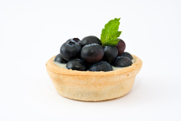 Delicious tartlets with raspberries and blueberries isolated on white background
