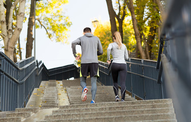 couple running upstairs in city park