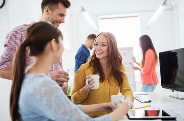 happy creative team drinking coffee at office