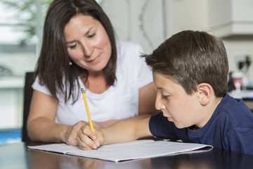 Mother Helping Son With Homework At Table