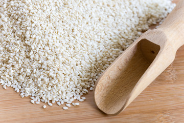 Pile of sesame with wooden measuring scoop