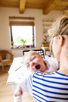 Mother at home holding crying baby