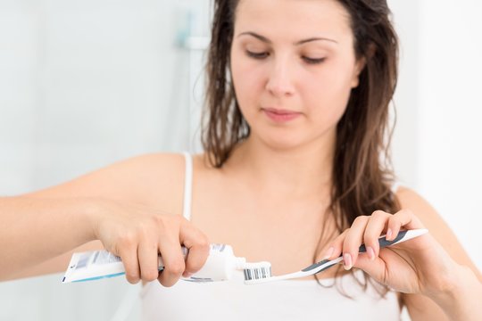 Woman Squeezing Toothpaste