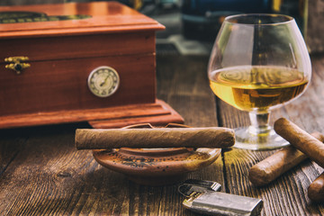 cigar and cognac with humidor in background - obrazy, fototapety, plakaty