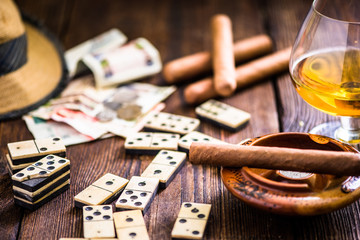 cuban cigar and domino on table