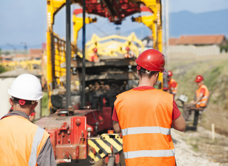 Rail construction site, railroad track installation workers, wit