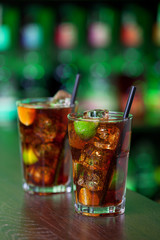 Cuba Libre is a famous Cuban cocktail. It is made of 2 oz light rum,juice of 1/2 limes,Coca-Cola. Shot on a bar in green light