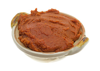 Bowl of red curry paste on a white background