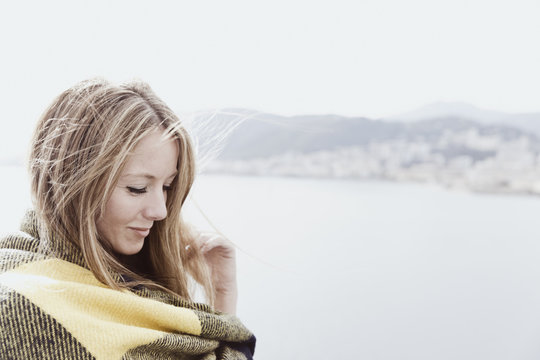 Portrait of blond woman covered with blanket on deck of a cruise liner