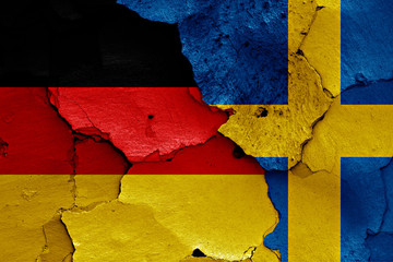 flags of Germany and Sweden painted on cracked wall
