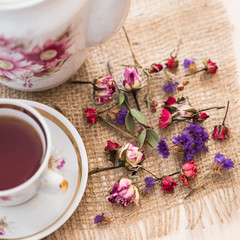 Obraz na płótnie Canvas Vintage cup of tea with buds of roses